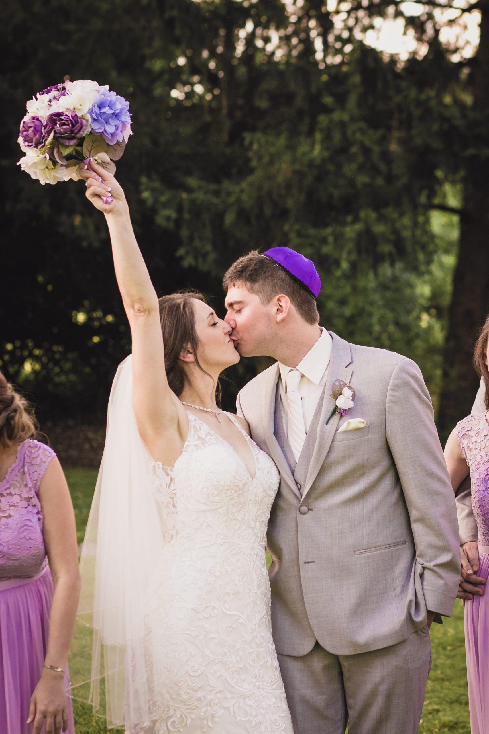 The Real Detroit Wedding of Sara and Jeffrey - Mike Staff Productions bride kissing groom while holding bouquet in the air