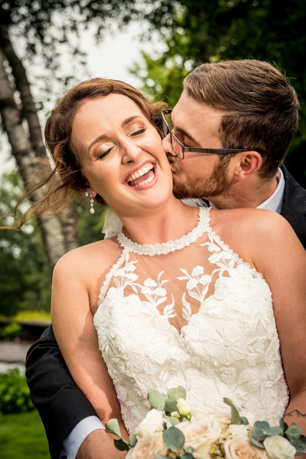 bride laughing while groom kisses her cheek - Mike Staff Productions