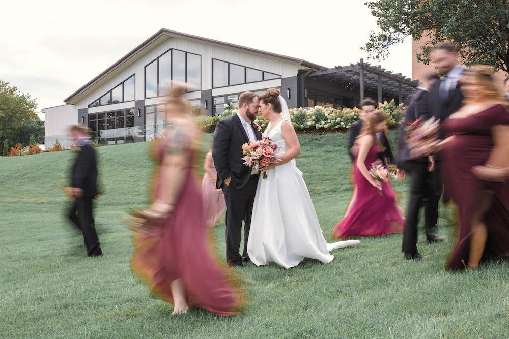 Detroit Wedding Photography at Marriott Eagle Crest_bride and groom outside bridal party walking by them